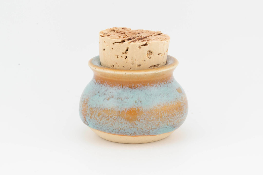 Mini corked jar with light blue ceramic glaze and cork lid.