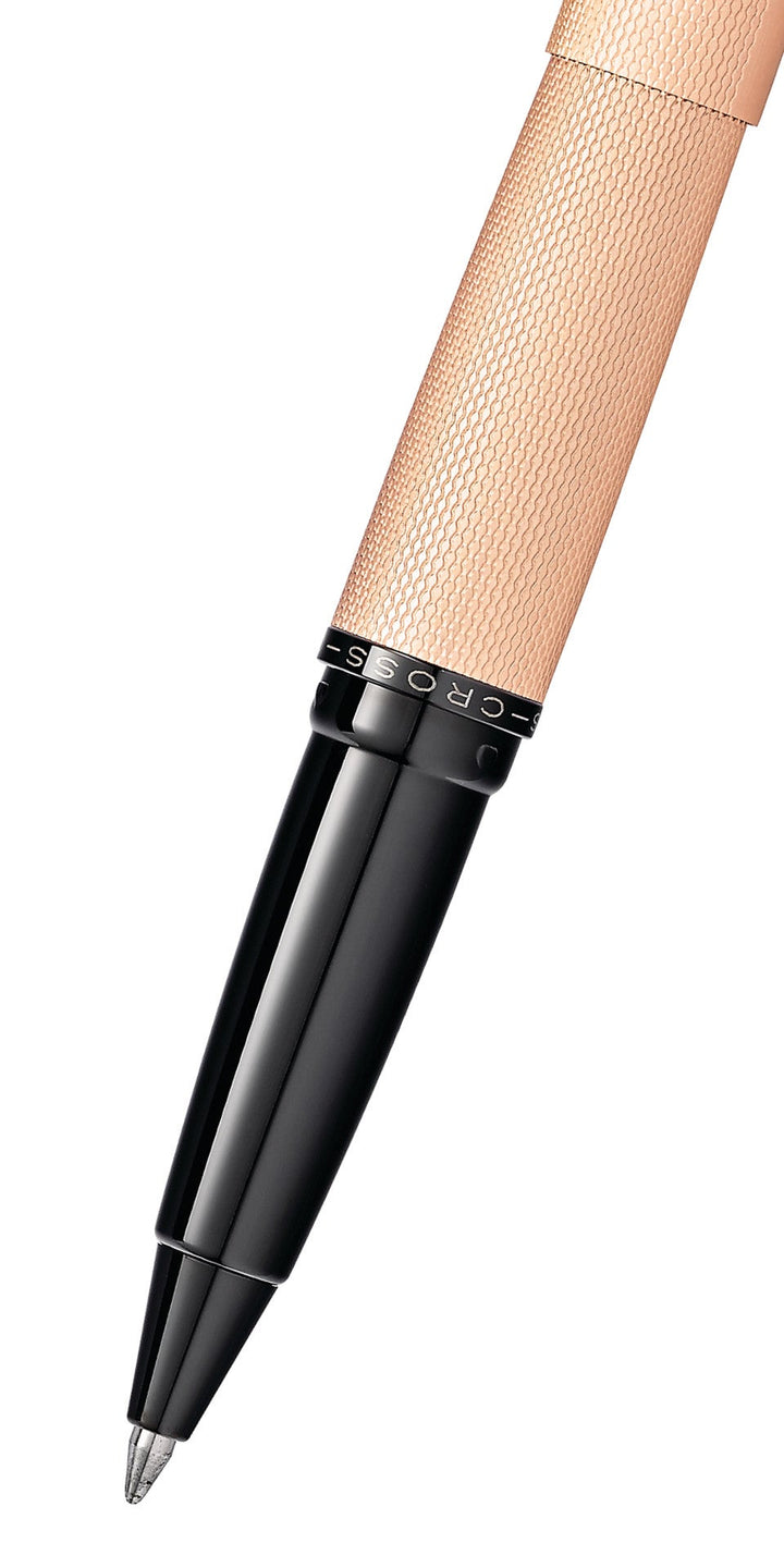 Close-up of rose gold rollerball pen tip and textured grip with black barrel