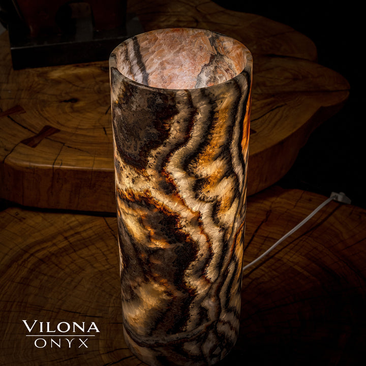 Dark onyx table lamp with amber-lit wavy channels and rounded top shade