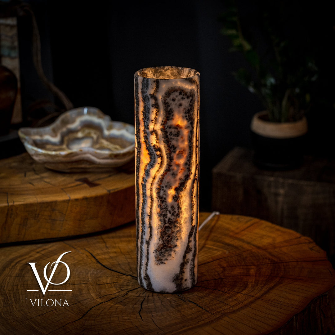 Onyx table lamp with tall crystal column, warm amber glow through stone veining