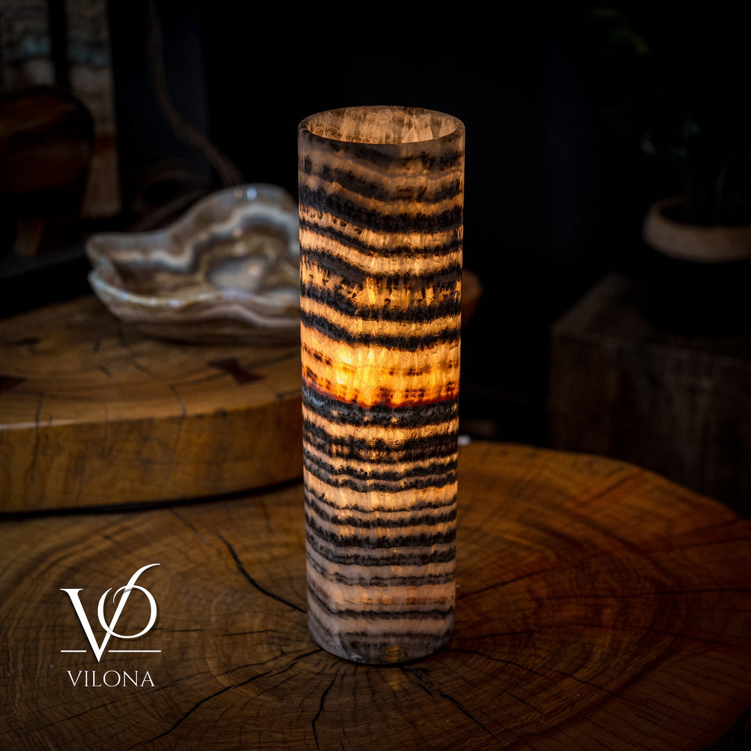 Cylindrical onyx crystal table lamp with bright amber glow through dark striped bands