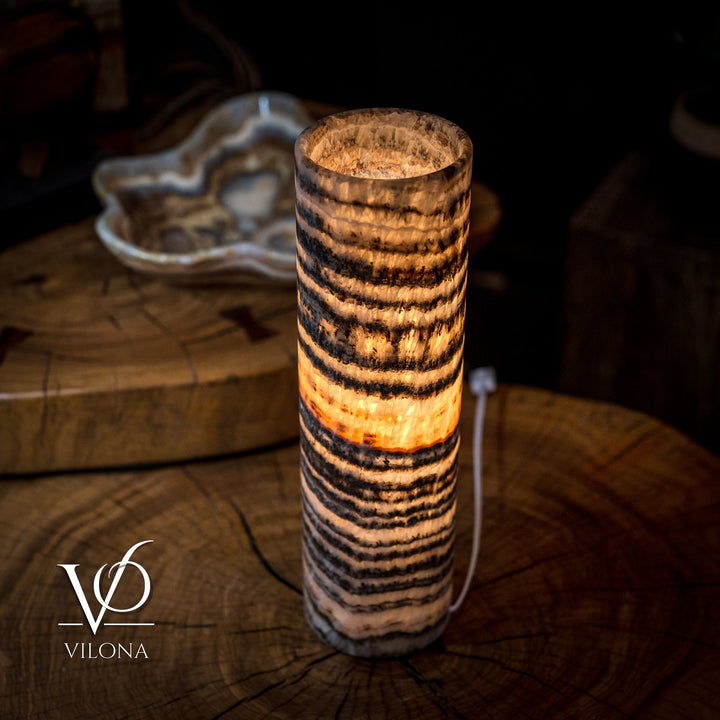 Cylindrical onyx crystal table lamp with amber glow and dark striped bands
