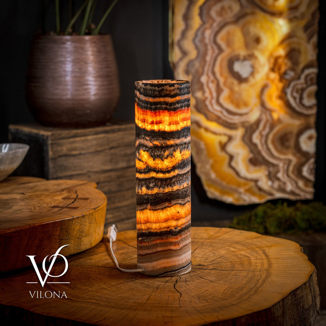 Cylindrical onyx crystal table lamp with warm orange glow and visible power cord.