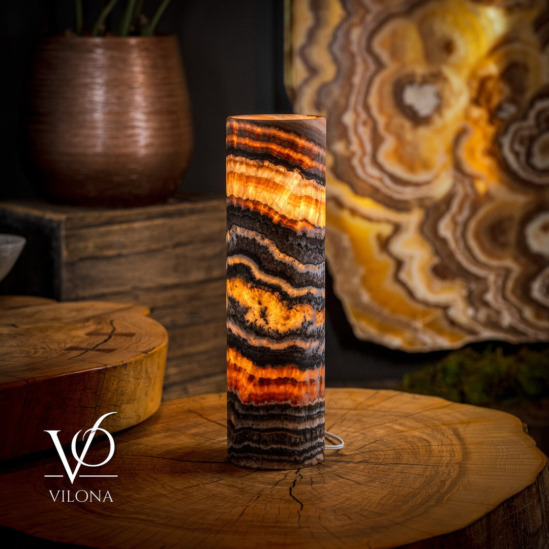 Onyx-striped column table lamp with warm-lit top, dark banding on shade
