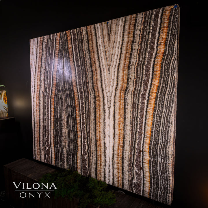 Striped onyx wall panel with cream, gray, and orange vertical streaks