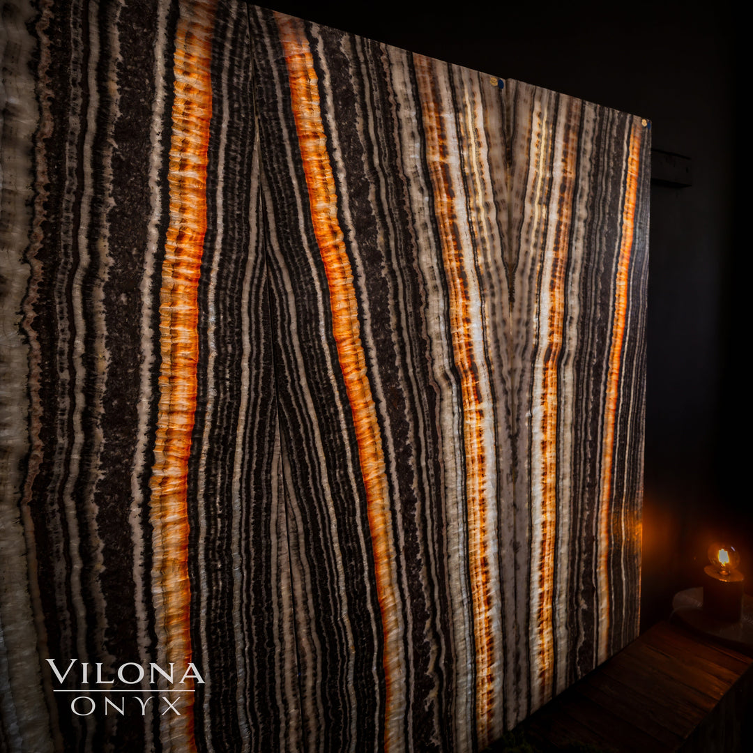 Striped onyx wall panel with tall vertical amber, cream, and charcoal lines