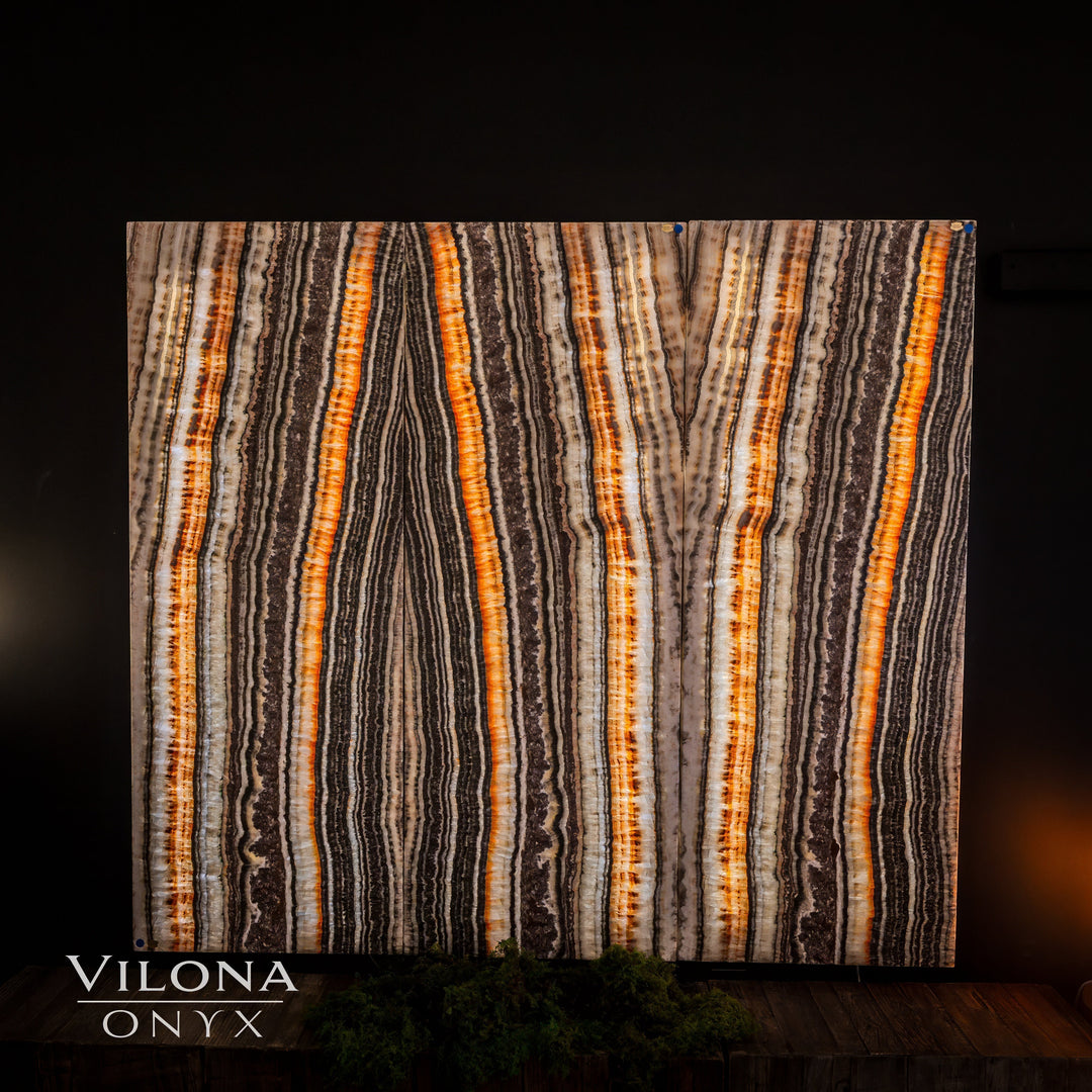 Striped onyx wall panel with bright orange and cream vertical veining on dark ground
