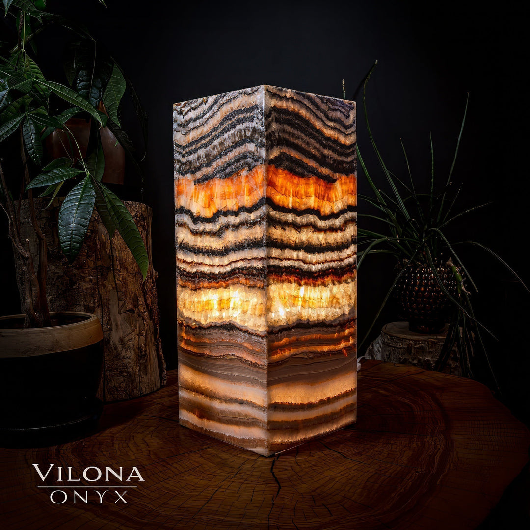 Medium square table lamp with striped onyx shade, warm orange glow