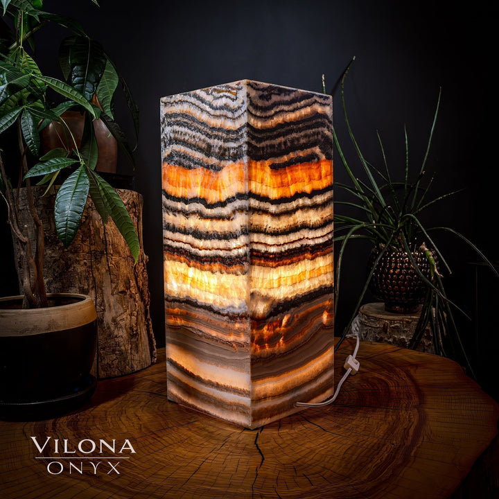 Medium square table lamp, front view of striped onyx shade with bright orange bands