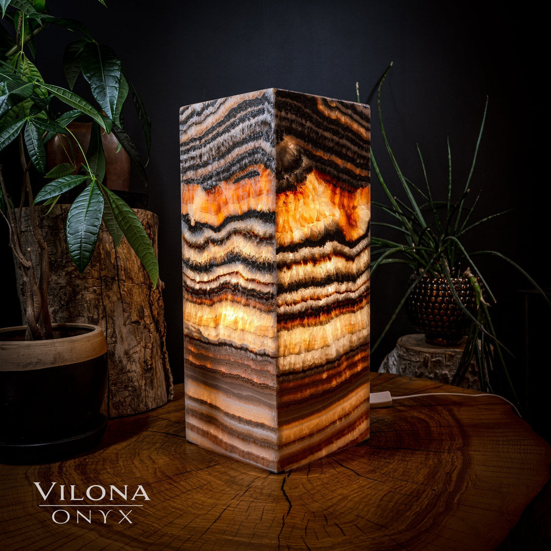 Square table lamp with faceted onyx slab, dark swirls and bright amber highlights