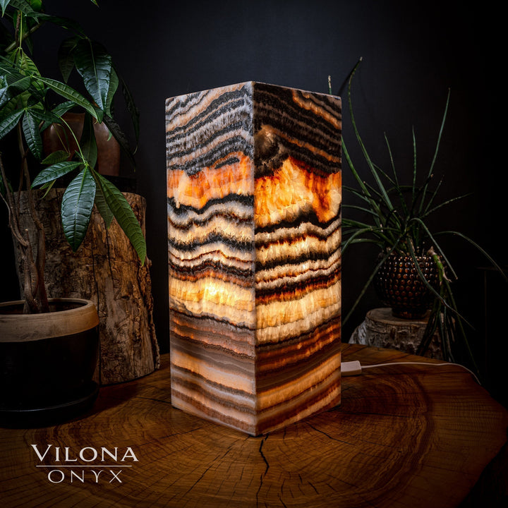 Square table lamp with faceted onyx slab, dark swirls and bright amber highlights