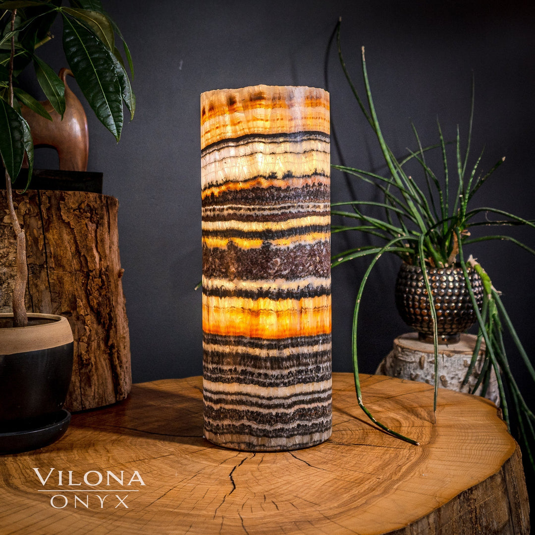 Medium table lamp with cylindrical onyx shade in orange, cream, and black stripes.