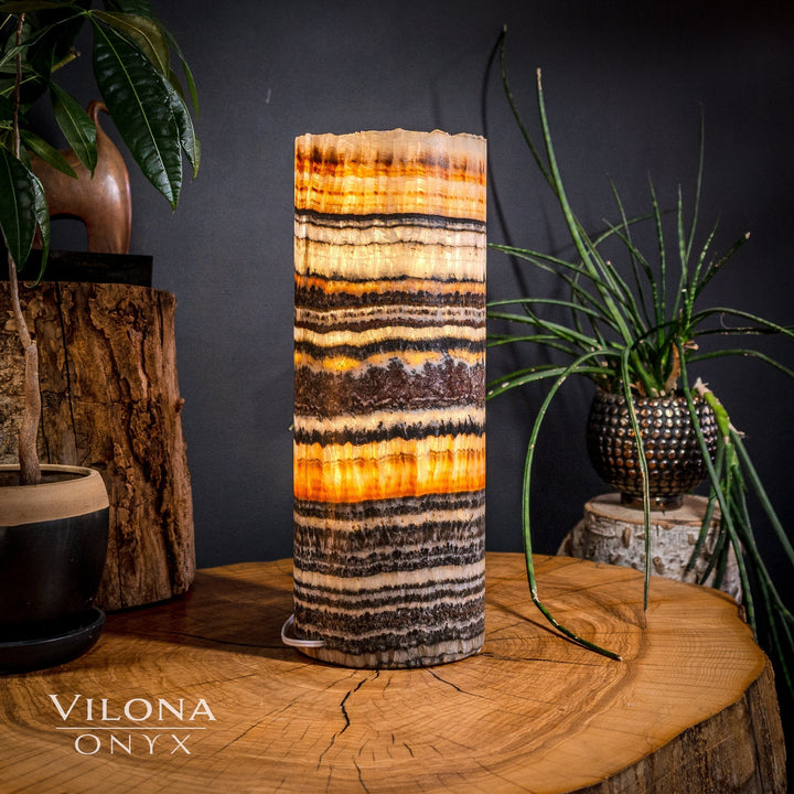 Medium onyx table lamp with a cylindrical shade featuring orange and dark stacked stripes.