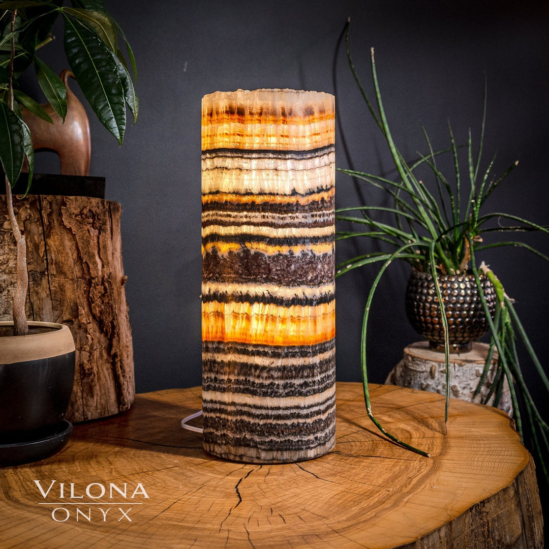 Tall cylindrical onyx table lamp with orange and black horizontal stripe bands on the shade.