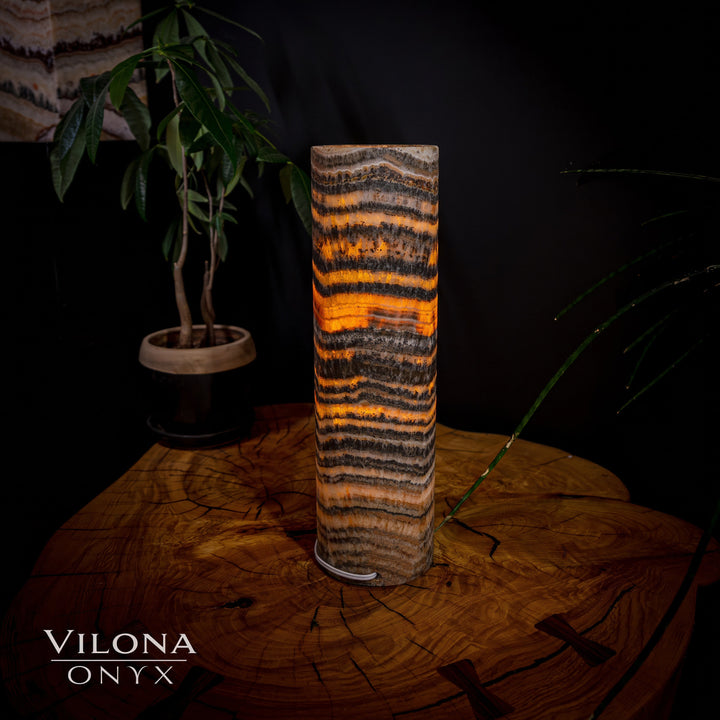 Table lamp with striped cylindrical onyx shade, amber tones with dark accents
