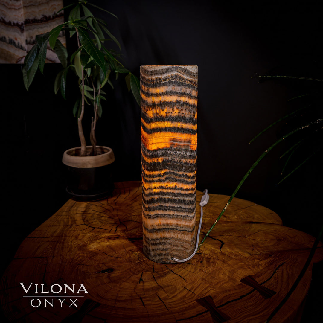 Table lamp with tall cylindrical onyx shade, bright amber stripes and dark veins