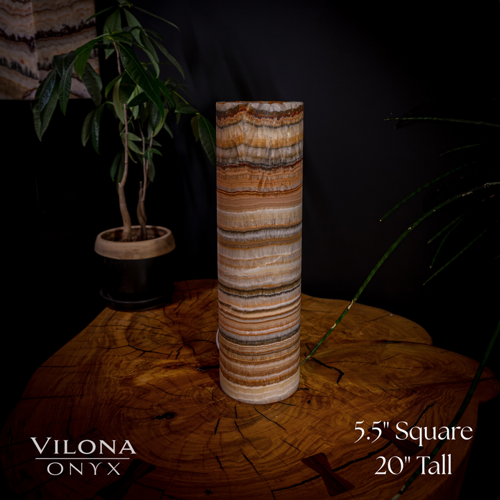 Cylindrical onyx table lamp with pale base edge and warm orange striped stone body