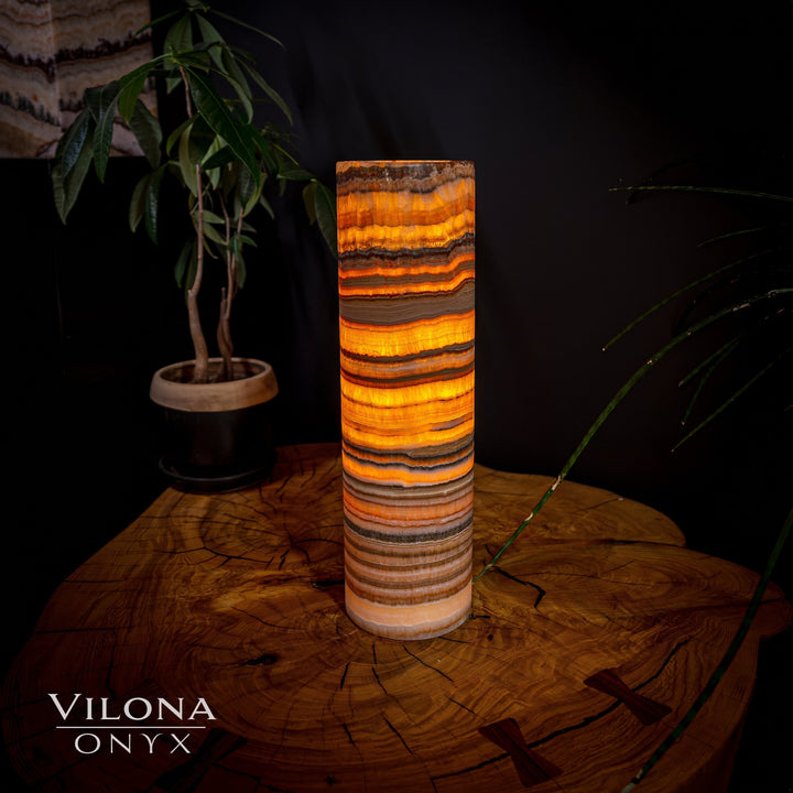 Cylindrical onyx table lamp with bright orange-gold and dark banded stone shade