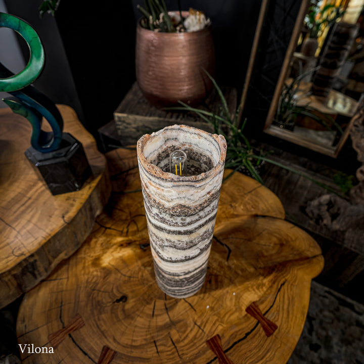 Cylindrical onyx-pattern table lamp with open top showing dark inner socket