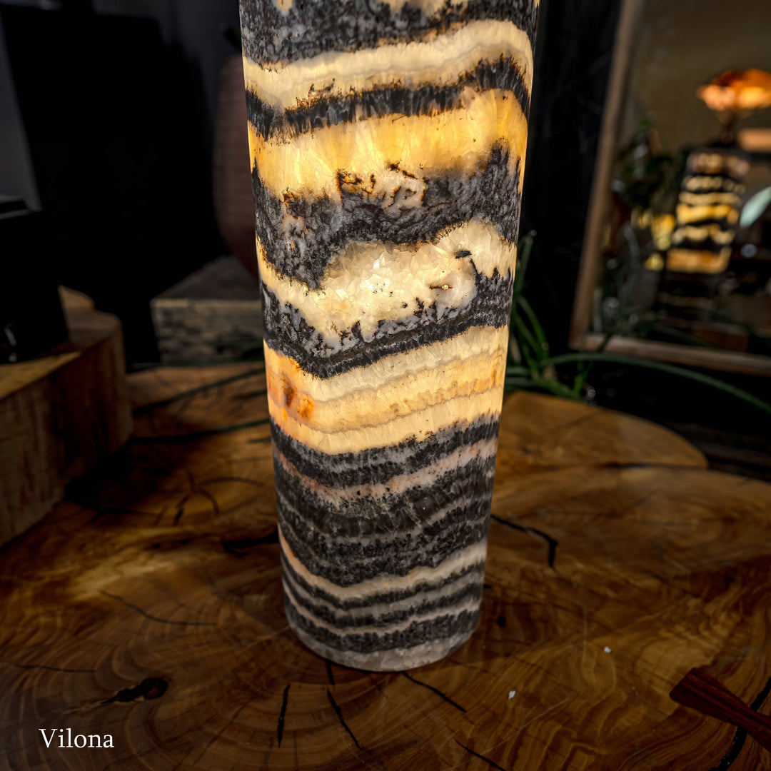 Onyx-pattern table lamp close-up with bold black, cream, and gold horizontal bands