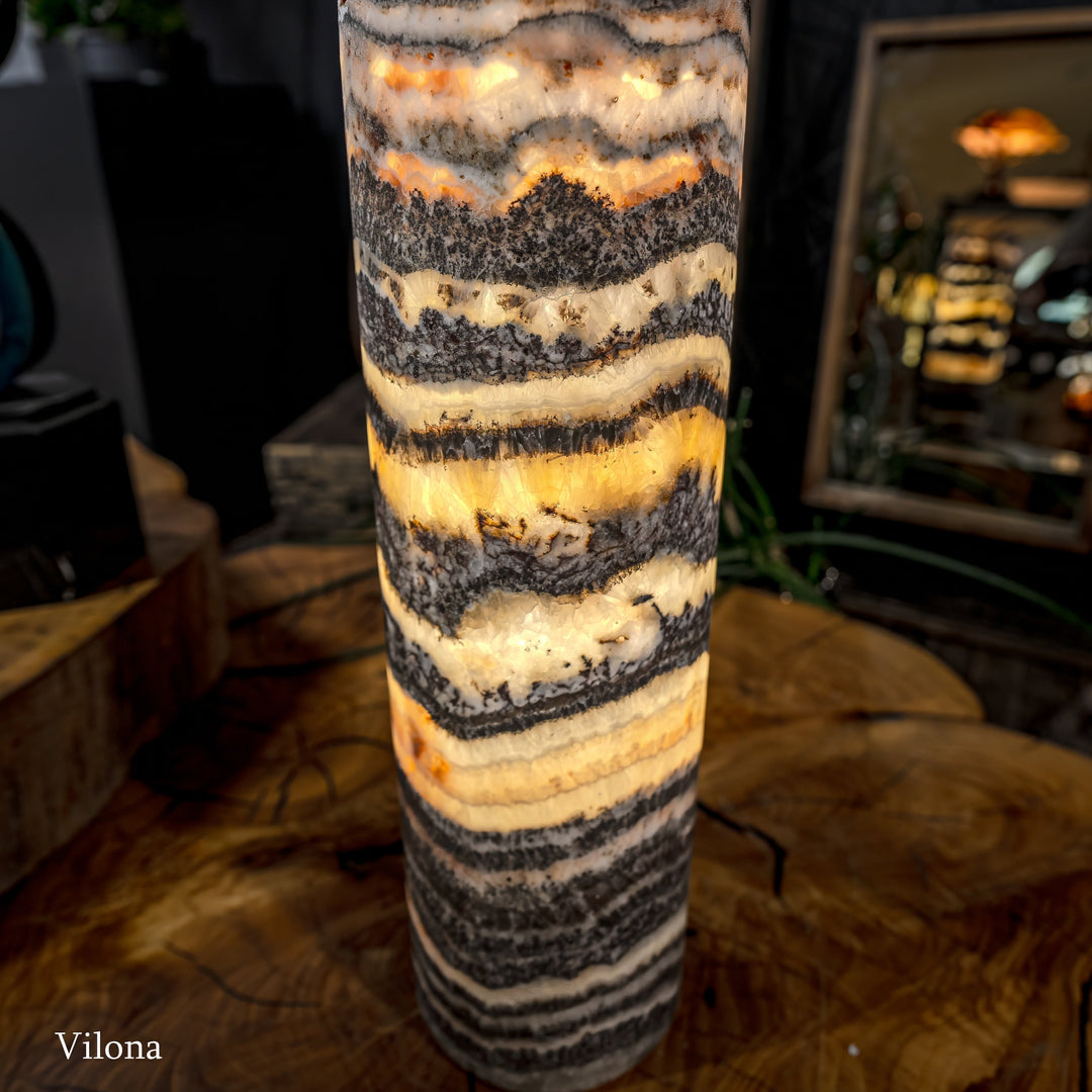 Cylindrical onyx-pattern lamp shade with warm glow and rough textured bands
