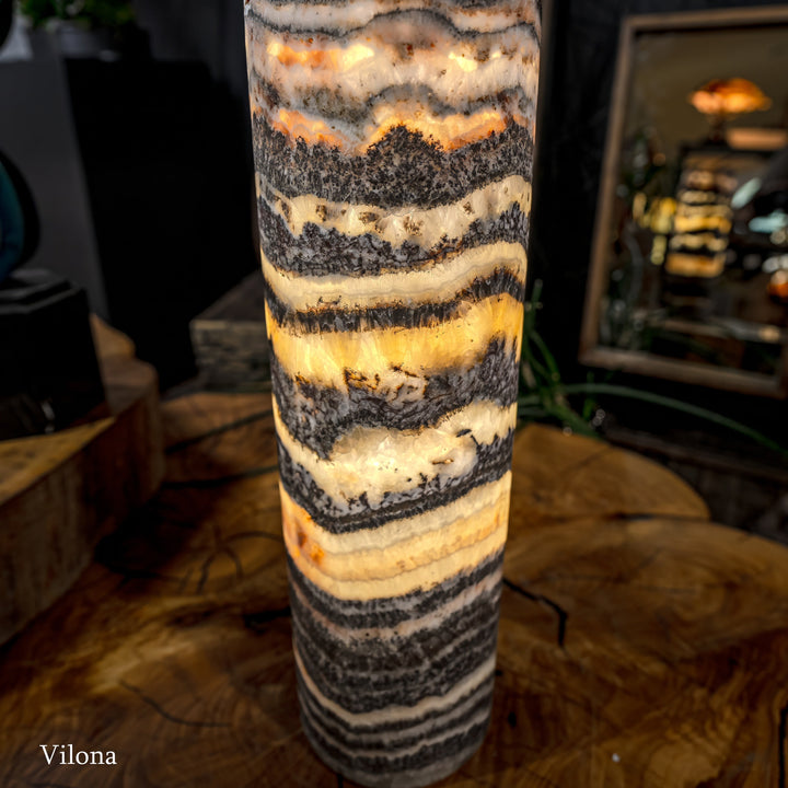 Cylindrical onyx-pattern lamp shade with warm glow and rough textured bands