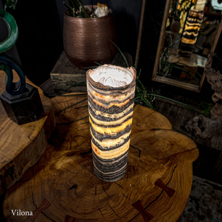Cylindrical onyx-pattern table lamp with warm glowing core and exposed socket at top