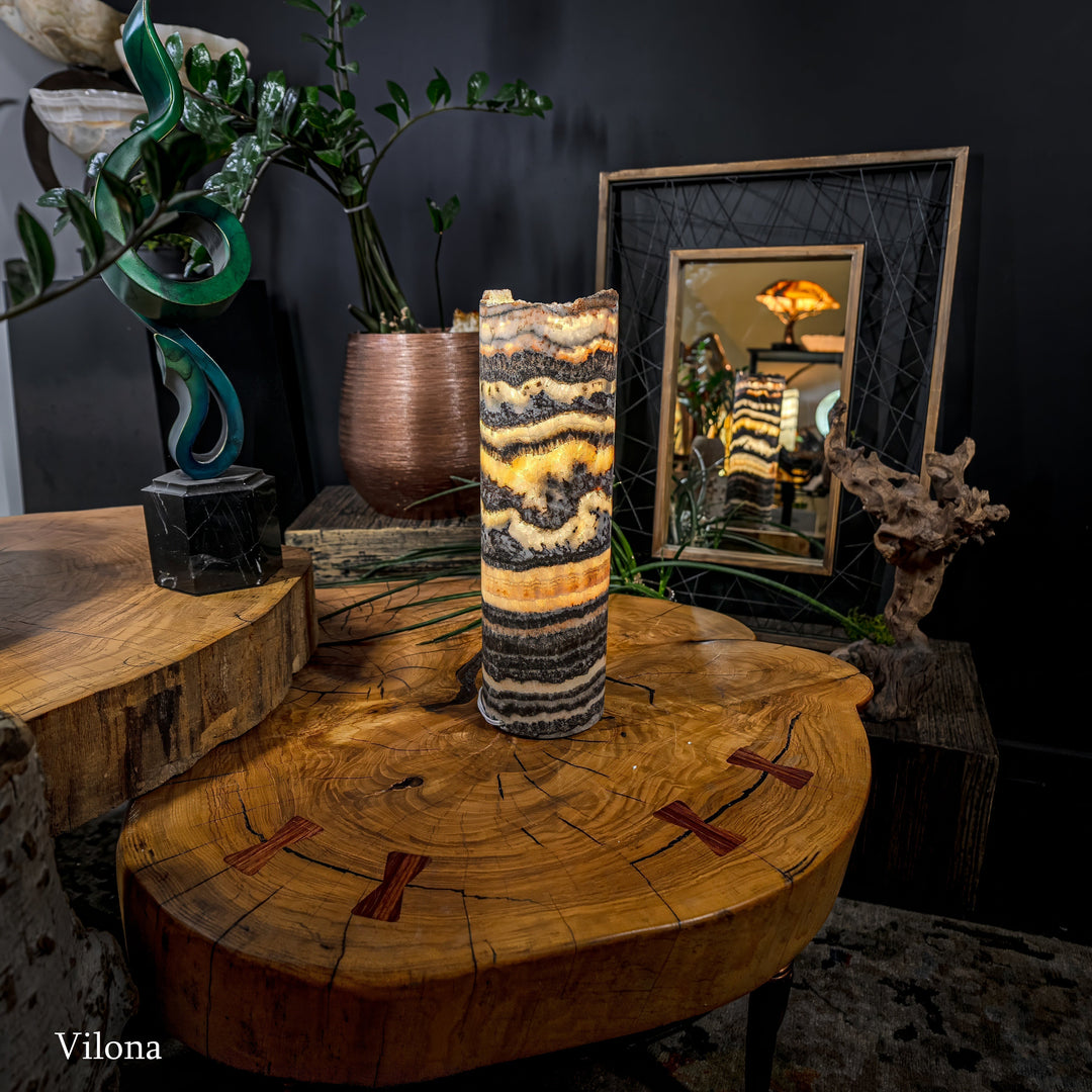 Cylindrical onyx-pattern table lamp with warm light and dark-to-cream band transitions