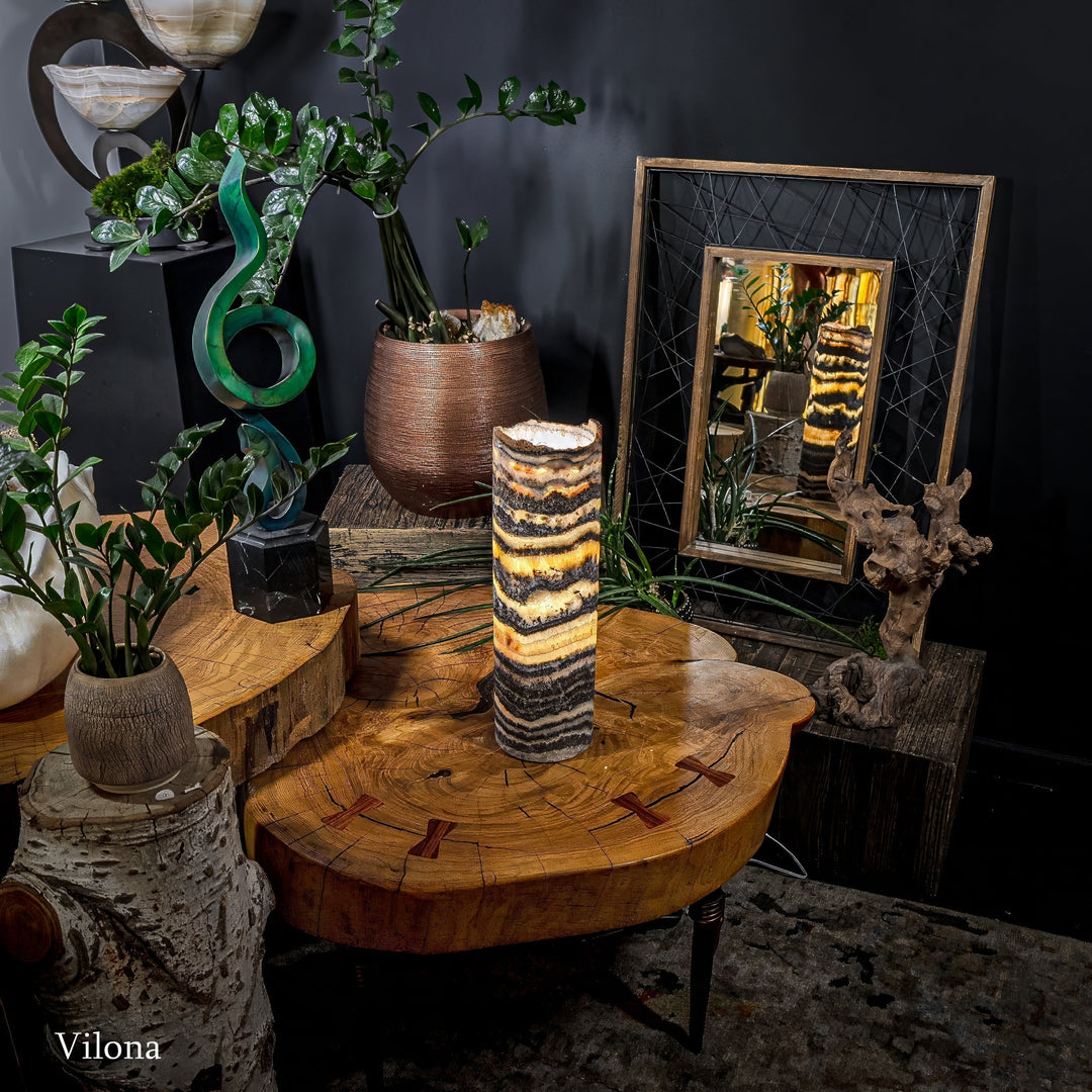 Cylindrical onyx-pattern table lamp standing on a round wooden side table