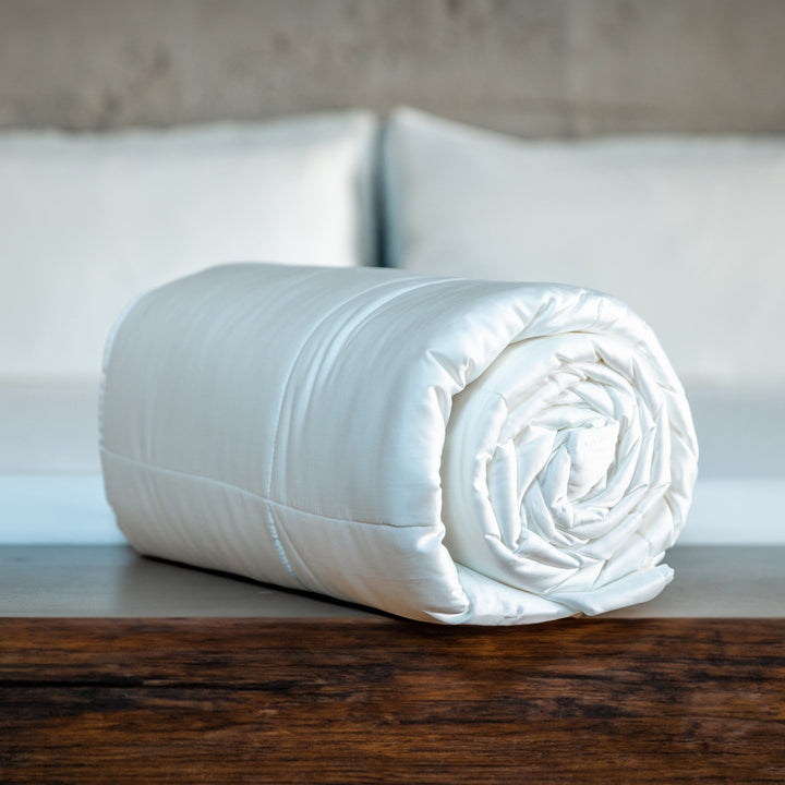 Light blue rolled comforter with stitched quilting and smooth fabric