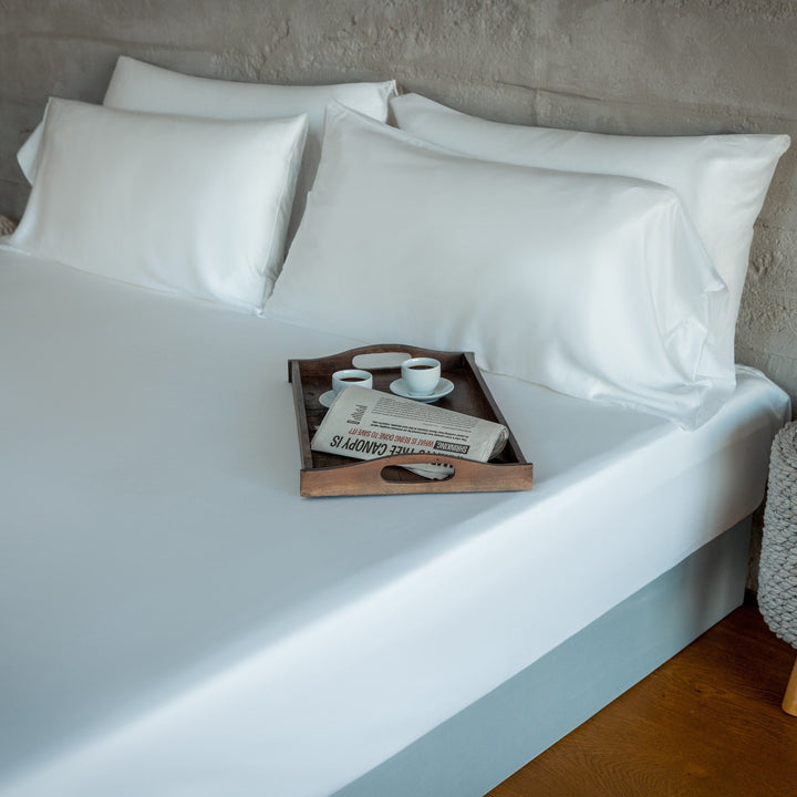 Light blue sheet and pillowcases neatly arranged on bed