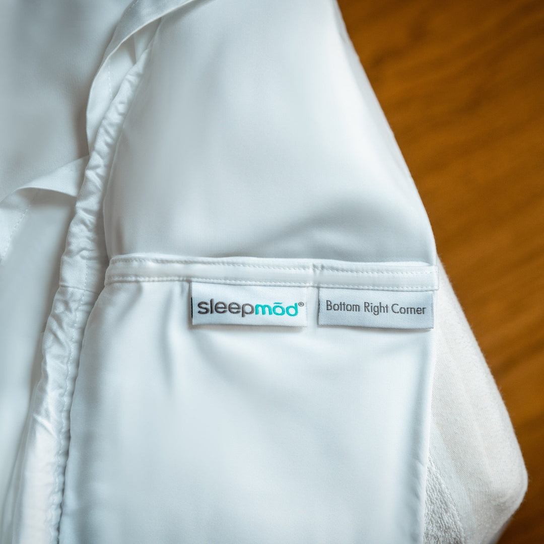 Light blue fitted sheet corner with sleepmod label and stitched edge