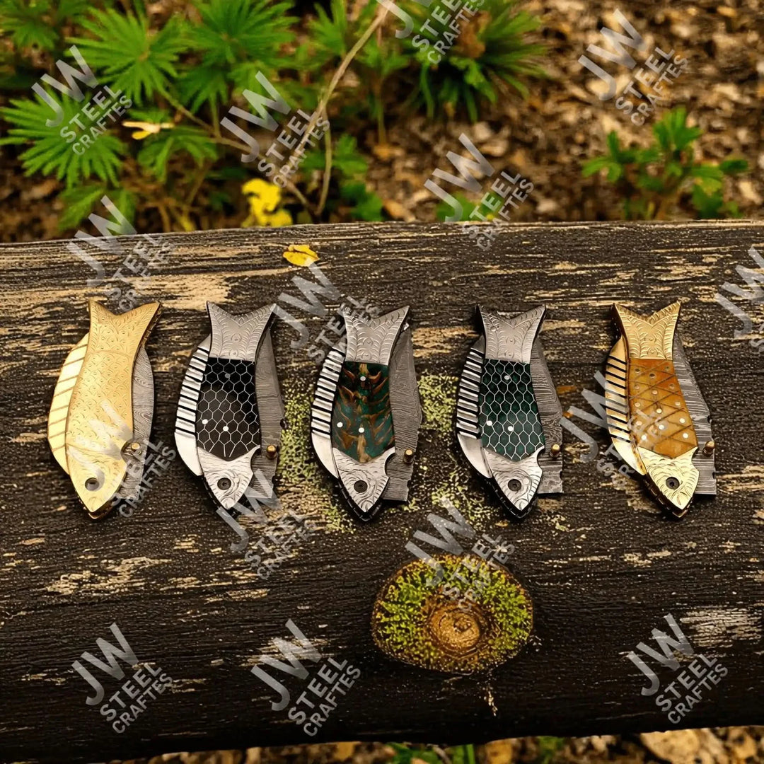 Damascus folding knives with gold, green, and brass-patterned handles on wood