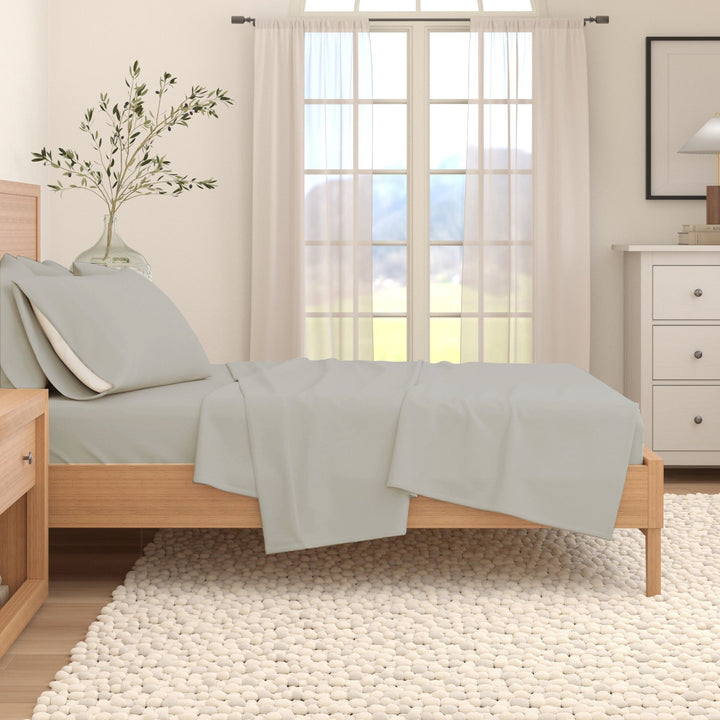 Solid cotton flannel sheet set in light grey on a bed with folded flat sheet