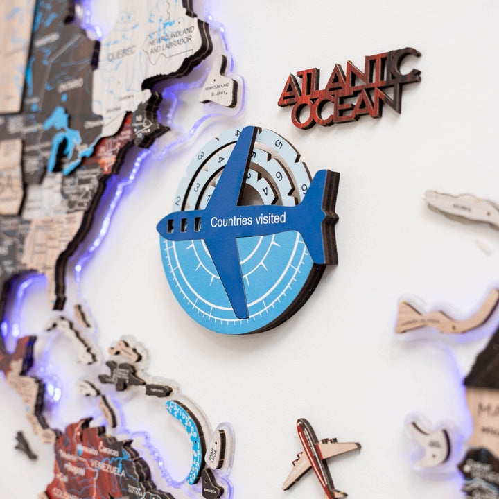 Blue 3D wooden compass travel tracker on a world map display