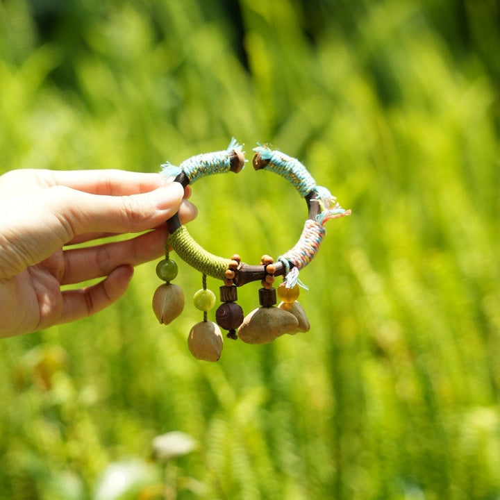 Seed bangle bracelet: braided green cord with multicolor tassels and wooden beads