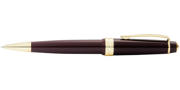 Burgundy resin ballpoint pen with gold-tone cap top, clip, and end rings