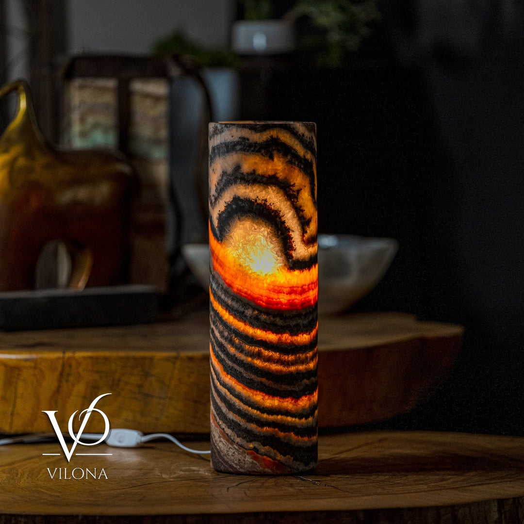 Table lamp with cylindrical onyx-look shade, black, amber, and orange striped glow