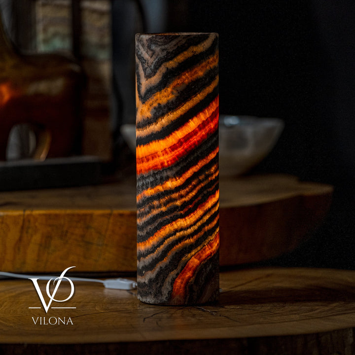 Cylindrical onyx-look table lamp shade with layered black and orange wave stripes