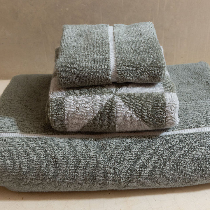 Sage-green cotton towels with white vertical bands and textured looped fabric