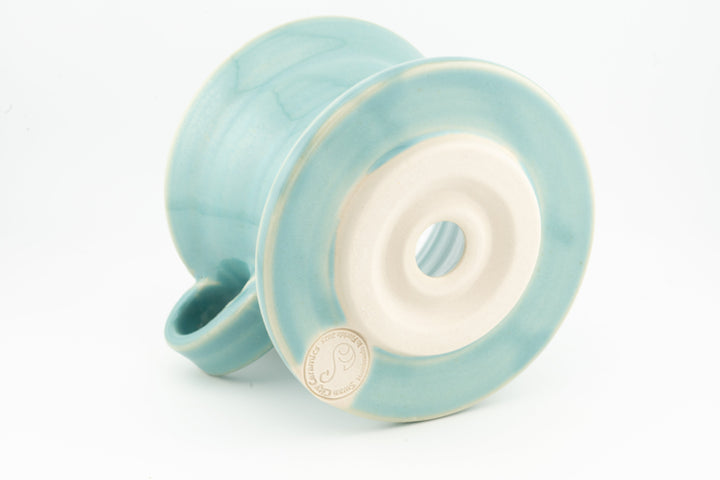V60 ceramic coffee dripper underside with circular vent, light turquoise glaze, side handle.