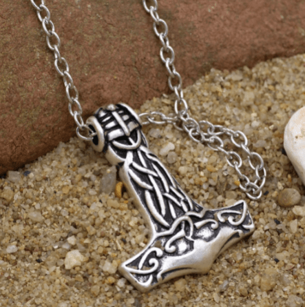 Silver-tone hammer pendant necklace with ornate interlaced pattern on chain.