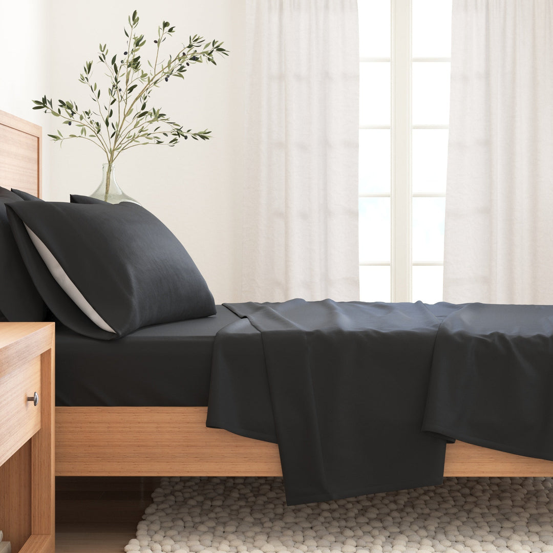 Cotton solid flannel sheet set in dark charcoal on a bed with pillow