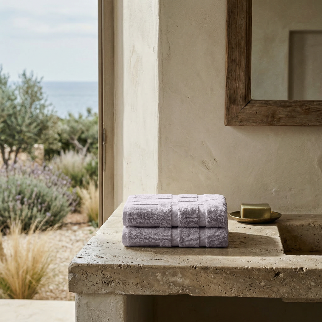 Lilac cotton towels folded stack on outdoor ledge
