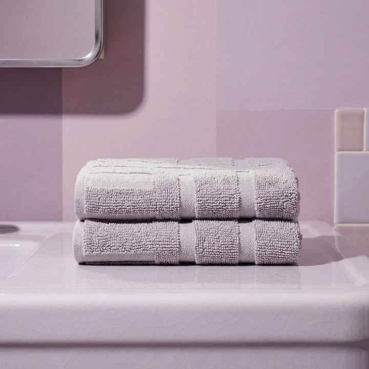 Cotton towels stack, two folded lavender towels with stitched stripe bands