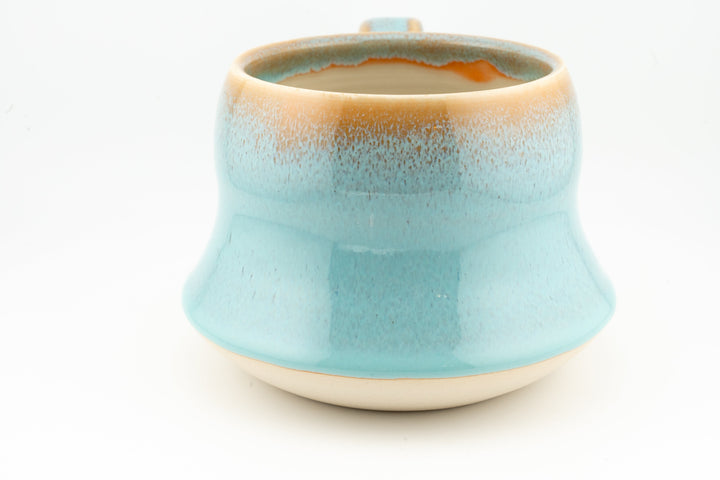Wide ceramic mug with turquoise-blue glaze and rounded base, glossy mottled finish