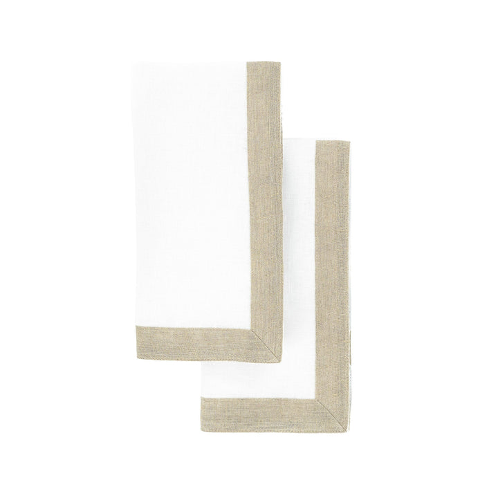 Overlapping linen napkins with white fabric and tan sparkle borders, shown in corner view.