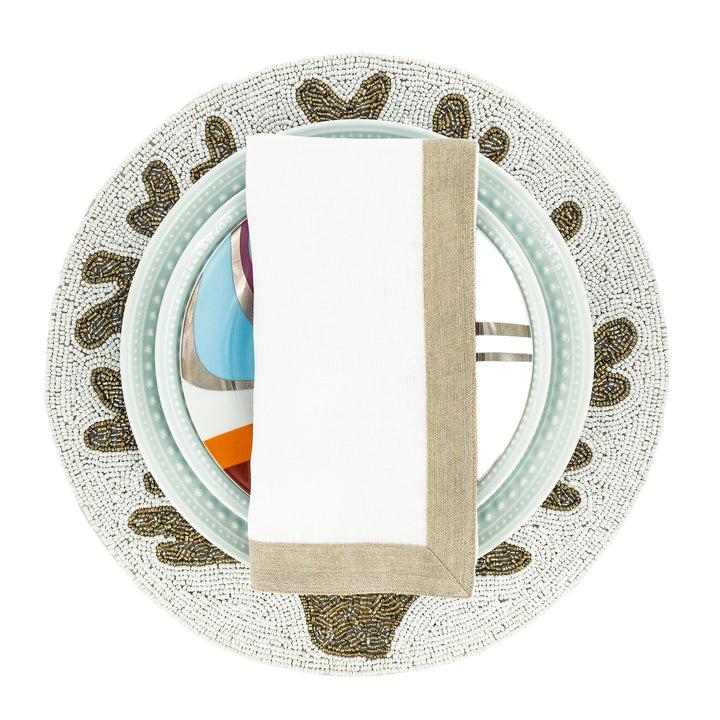 Linen napkin with white fabric and tan sparkle border, upright and centered.