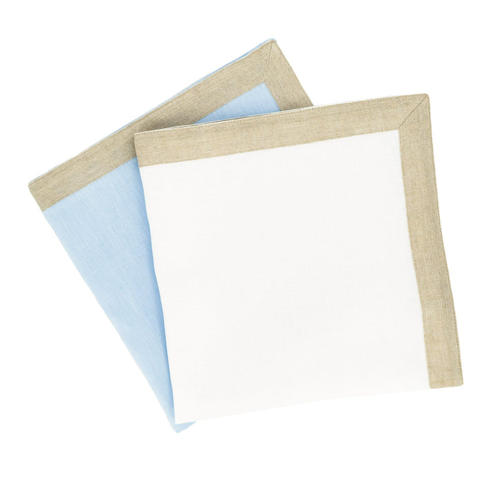 Stacked linen napkins: white napkin with tan sparkle border, with blue napkin partially behind.