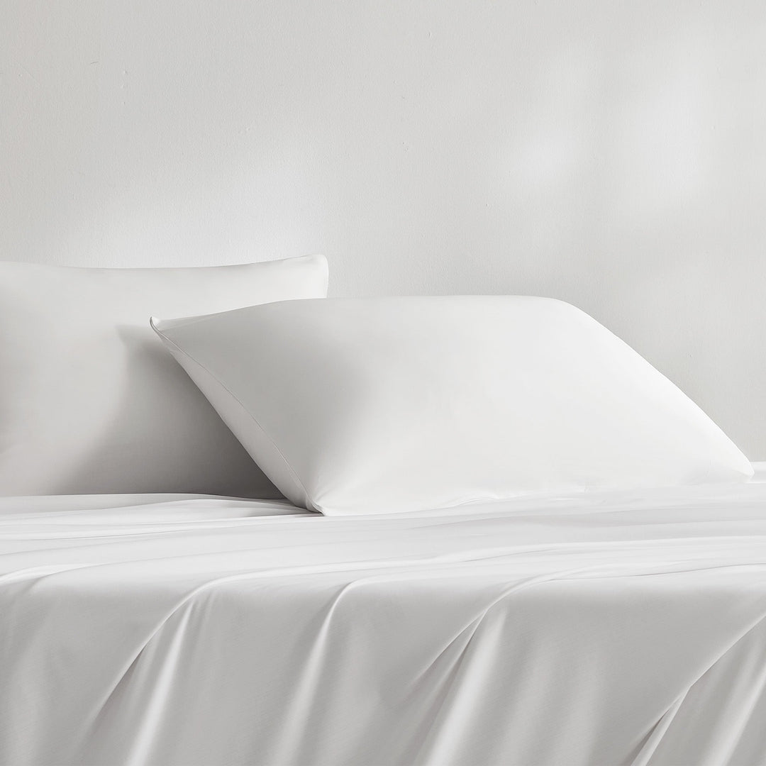 White pillowcase set with two pillows on a bed